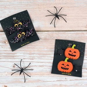 Detail of Halloween hair clips with glitter bats and pumpkin faces on card display