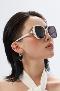 Détail de lunettes de soleil carrées blanches avec charnière en cristal et verres foncés