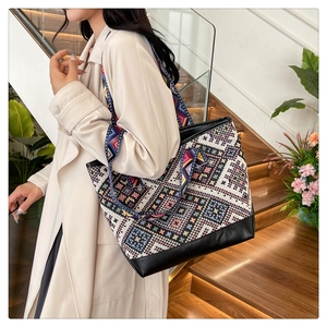 Ethnic tote bag with geometric patterns, colorful wide strap, and black PU leather base