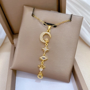 Close-up of gold tassel necklace with celestial charms and LIVE LOVE engraving