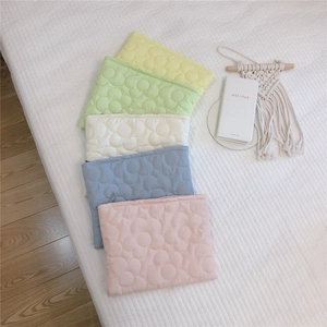 Close-up of colorful floral quilted down pouch bags in five pastel macaron shades