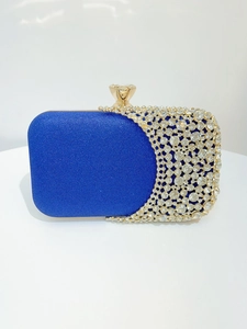 Close-up of royal blue evening clutch with shimmering fabric and crystal embellishments