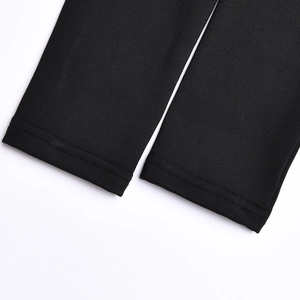 Nahaufnahme der schwarzen Stofftextur und der feinen Nähte am langärmeligen Kleid