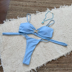 Close-up of light blue bikini top with metal starfish detail and matching necklace