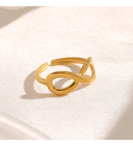 Macro shot of gold infinity symbol ring on white silk, showing smooth adjustable band