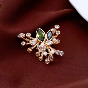Detailed view of luxury oval zircon brooch with pearls on elegant burgundy silk