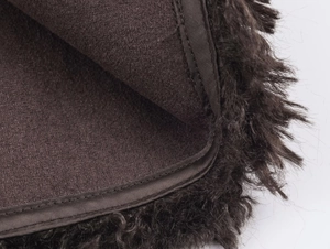 Detail of dark brown faux fur texture and precise stitching on plush jacket lining