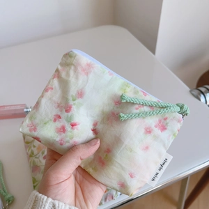 Close-up of floral cotton pouch with zipper and simple wish label detail