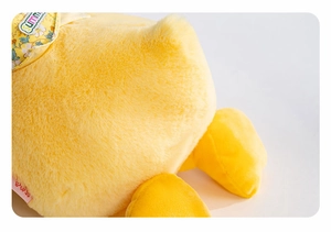 Close-up of a yellow plush duck showing soft texture and floral Summer bib detail
