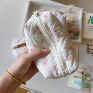 Gros plan détaillé de trousses de maquillage matelassées aux motifs floraux et nœuds