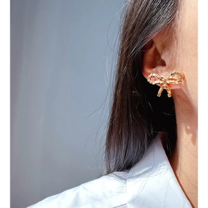Elegant woven golden bow earrings on model showing stylish square texture and craftsmanship
