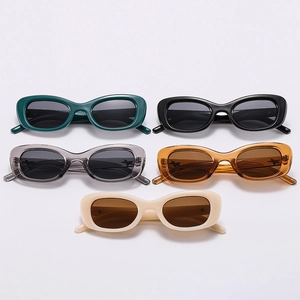 Flat lay collection of oval frame sunglasses in dark green, amber, and neutral colors