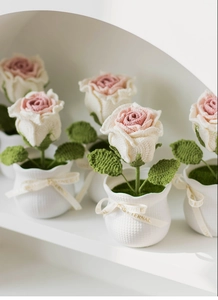 Detail of handmade crochet roses in white lattice pots with Love Is Eternal ribbon