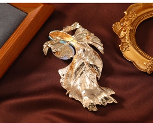 Detailed back view of vintage gold carp brooch with intricate metal textures and pin fastener
