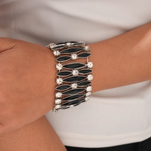Dettaglio di un bracciale elastico largo con pietre nere e cristalli trasparenti