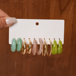 Detail view of 5-pair acrylic geometric hoop earrings with marble resin and gold finish