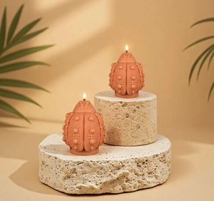 Detailed beetle silicone mold candle with textured surface and burning wick display