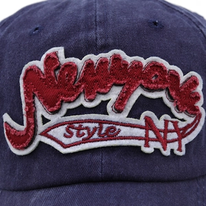 Close-up of vintage New York style 3D embroidery on washed navy denim baseball cap