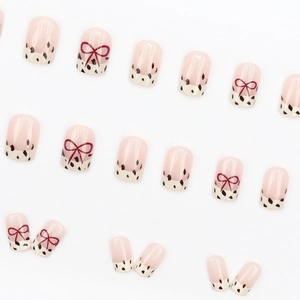 Quadratische nudefarbene Kunstnägel mit French Leopard-Print und roten Schleifen
