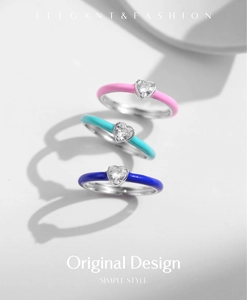 Detailed macro view of three stacked S925 silver heart rings with colorful enamel finishes