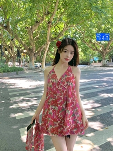 Close-up of red floral halter dress with lightweight fabric in a street style setting