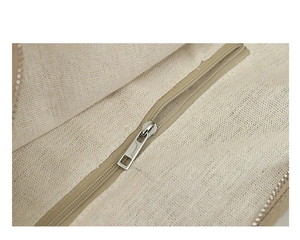 Dettaglio della cerniera in metallo e della fodera in tela resistente della borsa beige