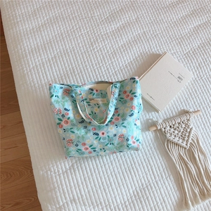 Detailed close-up of light blue floral cotton tote bag with intricate fabric texture