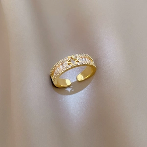 Nahaufnahme des verstellbaren Goldrings mit Stern und Kristallen auf edlem Satinstoff