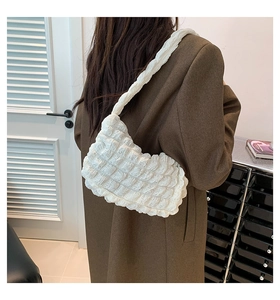 Detail of white bubble textured shoulder bag showing the soft pleated cloud fabric on model