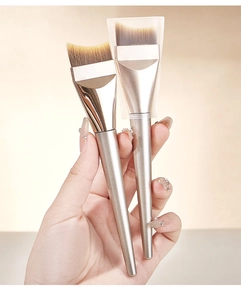 Detail of professional foundation brushes with soft brown bristles and gold handles