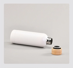 Close-up of white matte stainless steel bottle with natural bamboo lid and seal