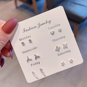 Detail of silver stud earring set with heart and star shapes on a weekly display card