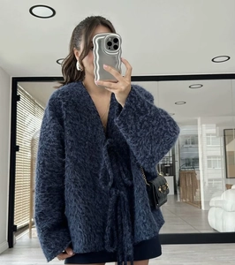 Close-up of fuzzy navy blue knit cardigan with waist tie and soft mohair texture
