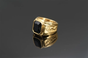 Macro shot of gold dragon ring featuring a square black gemstone and intricate side relief
