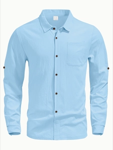 Detail of light blue linen shirt featuring a chest pocket and textured fabric blend