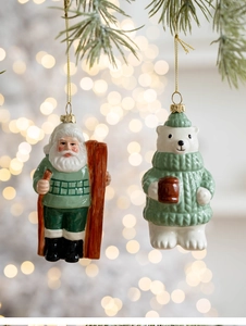 Detail of glossy Santa and polar bear ceramic Christmas tree ornaments on pine branches