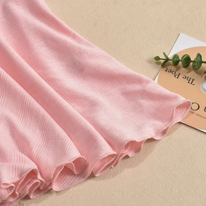 Detailed close-up of pink knit fabric showing hollow dot texture and vertical ribbing patterns