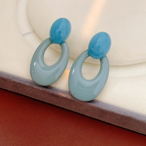 Detailed shot of retro blue resin oval earrings on a jewelry display stand
