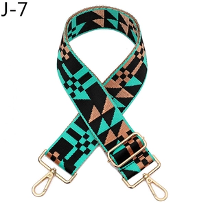 Detail of adjustable geometric wide bag strap with teal brown pattern and gold metal hooks