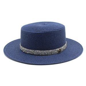 Detail of navy straw sun hat with silver rhinestone band and metallic M logo emblem
