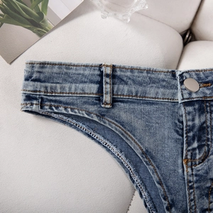 Détail de la taille en jean avec coutures jaunes et bouton en métal sur short bleu