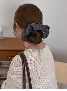 Detail of grey striped fabric scrunchie worn on hair, soft textile texture and pattern