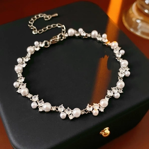 Detailed close-up of geometric pearls and zircon bracelet with silver adjustable chain