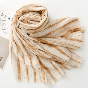 Detail of cream scarf with brown gradient stripes, silver glitter and fringed edges