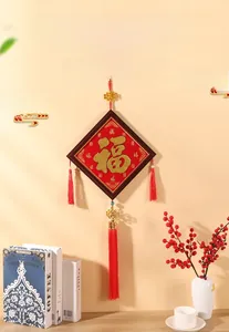 Détail d'un cadre de nœud chinois rouge festif avec caractère Fu doré et long gland