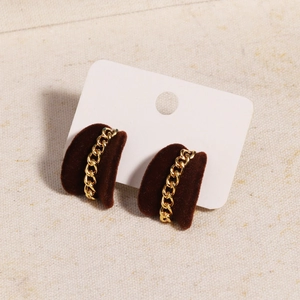 Close-up of heart-shaped burgundy flocked earrings with elegant gold chain trim