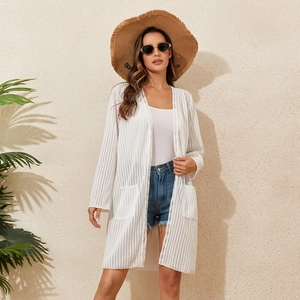 Détail de la texture en maille blanche et des poches latérales de ce cardigan de plage