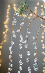 Macro shot of acrylic crystal beads on a festive branch with warm bokeh background