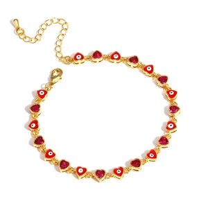 Detail of gold heart link bracelet with red stones and evil eye enamel charms