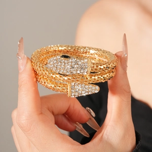 Detailed close-up of snake wrap bracelet with gold finish and sparkling rhinestones